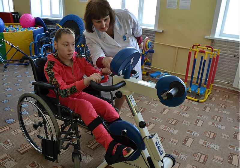 девочка  в инвалидной  коляске тренируется